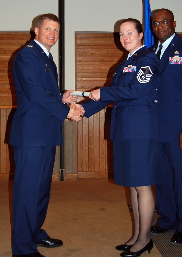 (Middle) Master Sgt. Dawn Kaighen, 926th Aerospace Medicine Flight, receives her Associate in Applied Science Degree in Allied Health Sciences from Col. Howard Belote, 99th Air Base Wing commander (left), during the Community College of the Air Force commencement ceremony here Oct. 27.