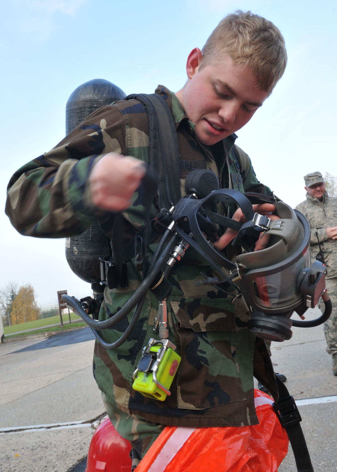 SPANGDAHLEM AIR BASE, Germany -- Airman 1st Class Scott Carrol, 52nd Civil Engineer Squadron, demonstrates how to put on a class-A hazmat response suit during an on-scene commander's course Oct. 30. The course gave individuals training and certification to be a commander of an incident or work in an emergency operations center. (U.S. Air Force photo/Airman 1st Class Nick Wilson) 