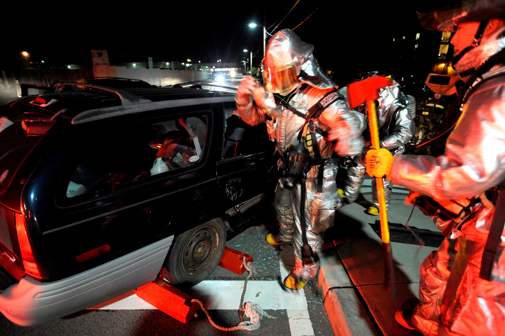 Fire fighters from the 51st Civil Engineer Squadron prepare to use the jaws of life on a car door during a simulated car accident at Osan Air Base, Republic of Korea, Nov. 2.  The simulation is part of operational readiness exercise Beverly Midnight 09-02. (U.S. Air Force photo/Staff Sgt. Brian Ferguson)