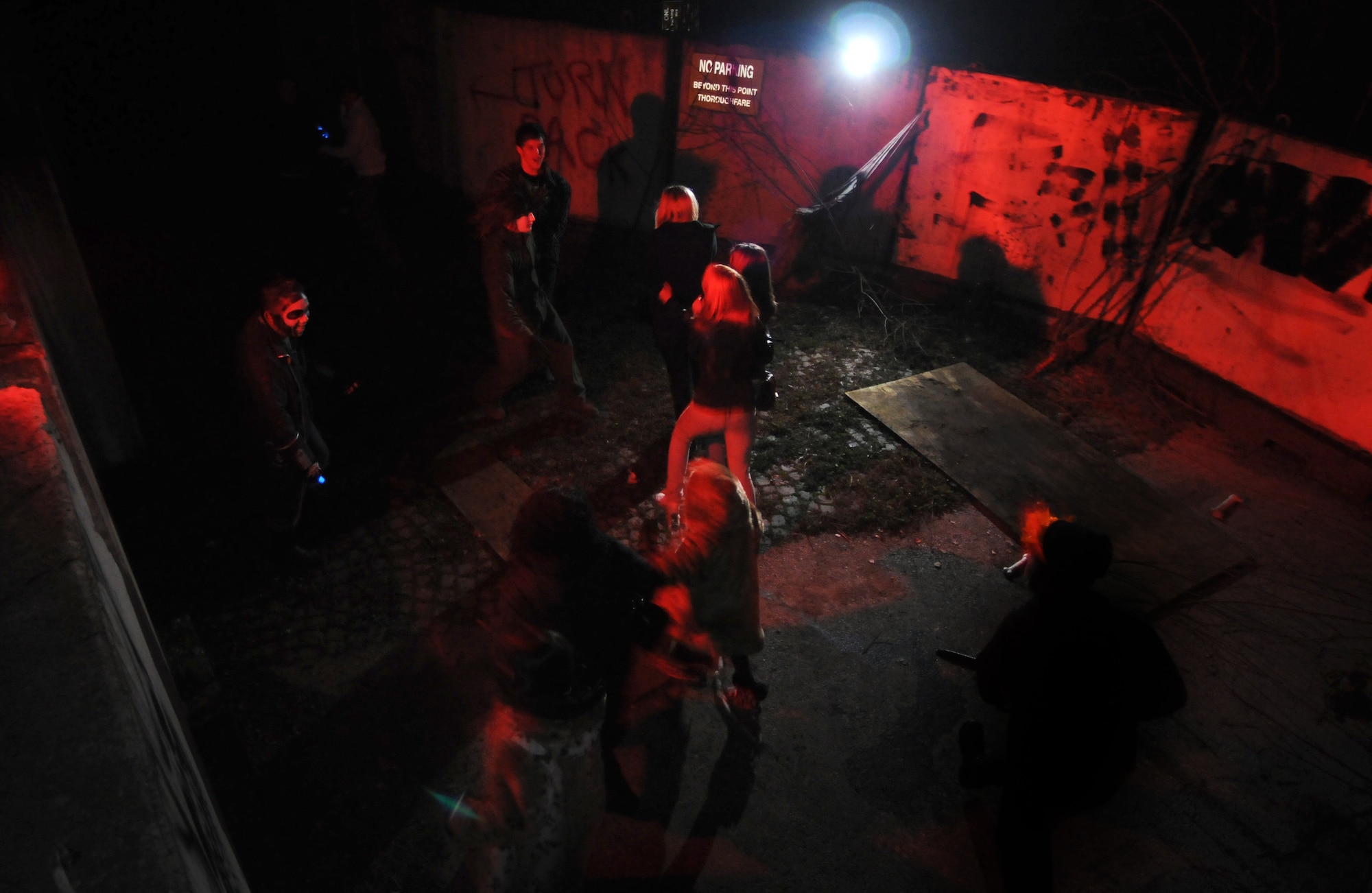 BITBURG ANNEX, Germany -- Visitors of the Bitburg Haunted House run from a crazed villain with a chain saw here Oct. 30.The haunted house was open for Halloween weekend and was available to the local population to participate in the festivities. More than 1,700 people attended the event. (U.S. Air Force photo/Airman 1st Class Nathanael Callon)