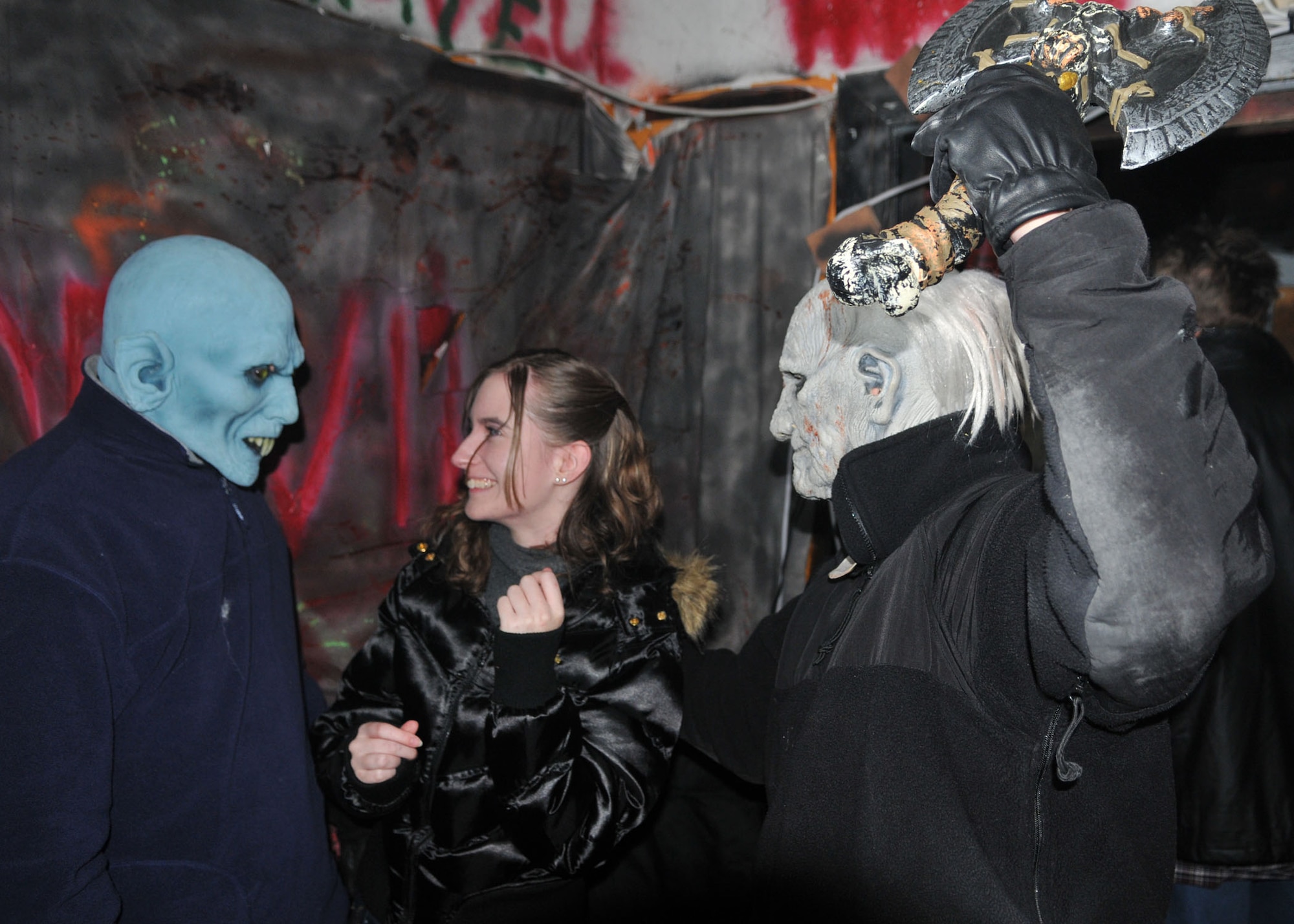 BITBURG ANNEX, Germany -- Stephanie Hattabi, a local German resident, gets a scare from two actors in costume at the haunted house in the Bitburg Annex Oct. 31. This annual Halloween event, available to both Germans and Americans, took visitors on a 15-minute tour through a house of dressed up killer-clowns, ghouls, goblins, graveyards, chain saws and axe murderers. More than 1,700 people attended the event, with more than 400 from the local area. (U.S. Air Force photo/Airman 1st Class Nick Wilson)