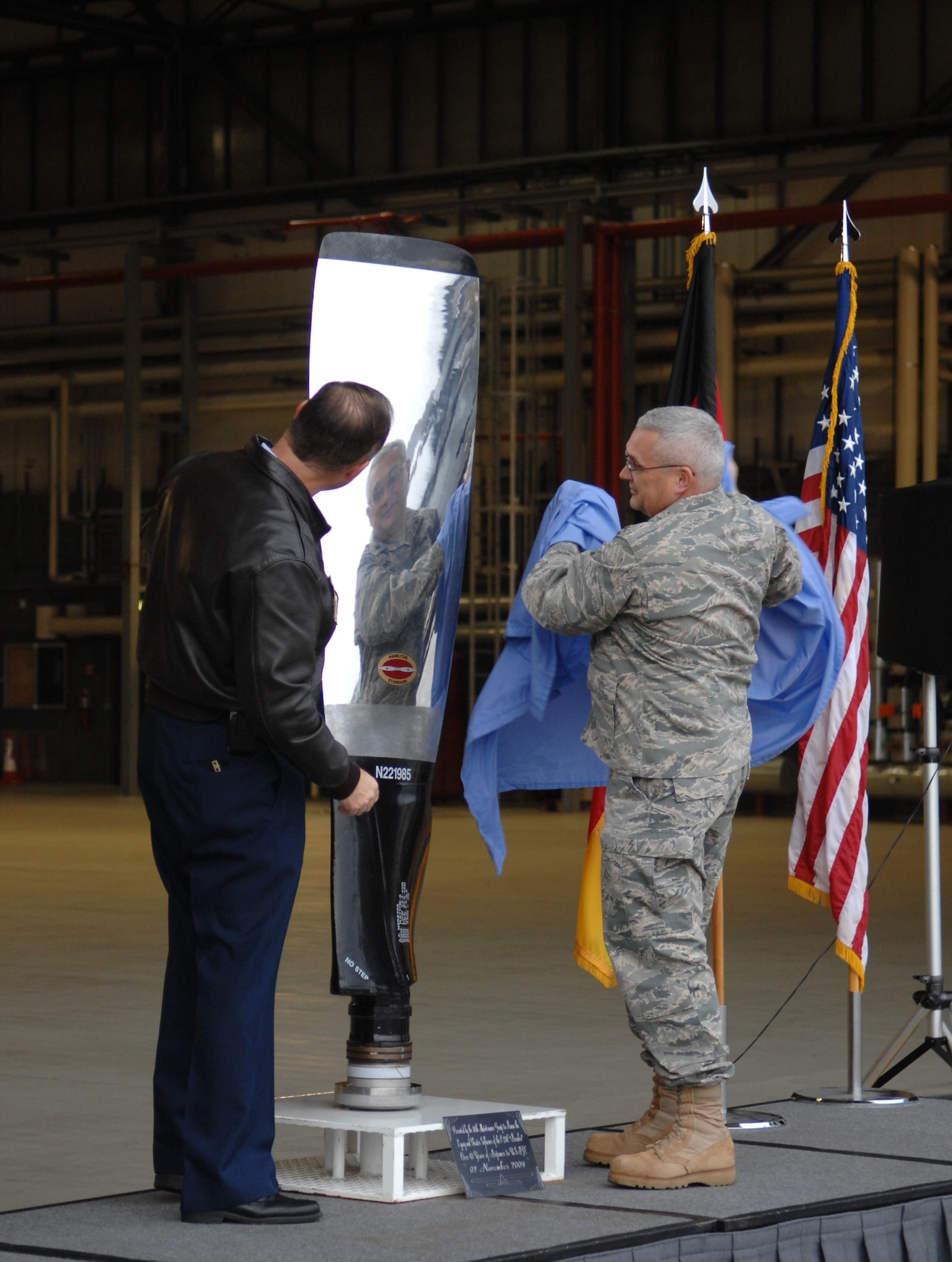 U.S. Air Force Lt. Col. Timothy Moore(right), 86th Maintenance Squadron deputy commander, presents Col. Douglas Sevier, 86th Airlift Wing vice commander, with a legacy presentation on behalf of the 86th Maintenance Squadron during a final departure ceremony on Ramstein Air Base, Germany, Nov. 2, 2009. The C-130E Hercules has provided more than 40 years of airpower to U.S.  Air Forces in Europe, and is being replaced with the new C-130J Super Hercules as part of the revitalization of the Air Force fleet. (U.S. Air Force photo by Airman 1st Class Brittany Perry)