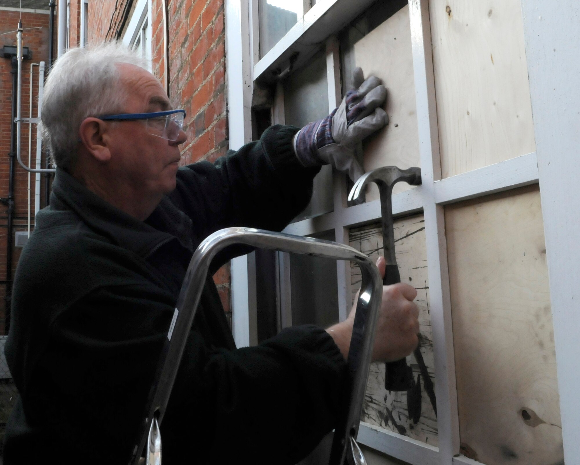 RAF MILDENHALL, England -- John Ridding from the 100th Civil Engineer Squadron, boards up a broken window at the 100th Air Refueling Wing headquarters building Oct. 28.  As a carpenter in the structures shop, Mr. Ridding is responsible for everyday repairs to buildings on the base.  (U.S. Air Force photo/ Staff Sgt. Christopher L. Ingersoll)