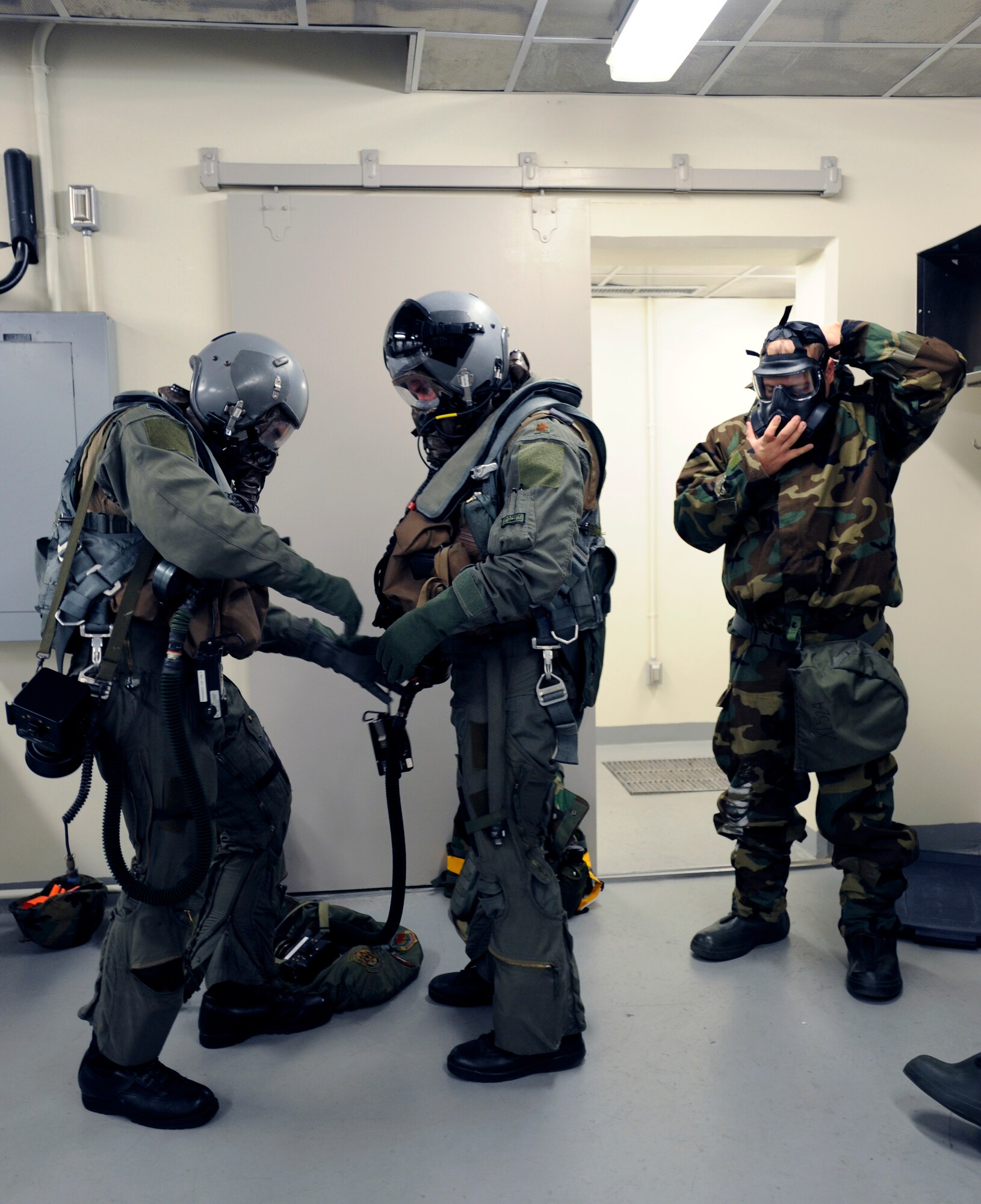 Lt. Col. Stephen Renner, left, helps Maj. Jeffrey Ferguson properly secure his equipment before going through a simulated decontamination scenario at the 25th Fighter Squadron during exercise Beverly Midnight 09-02 on Osan Air Base, Nov. 2. (U.S. Air Force photo/Senior Airman Stephenie Wade)