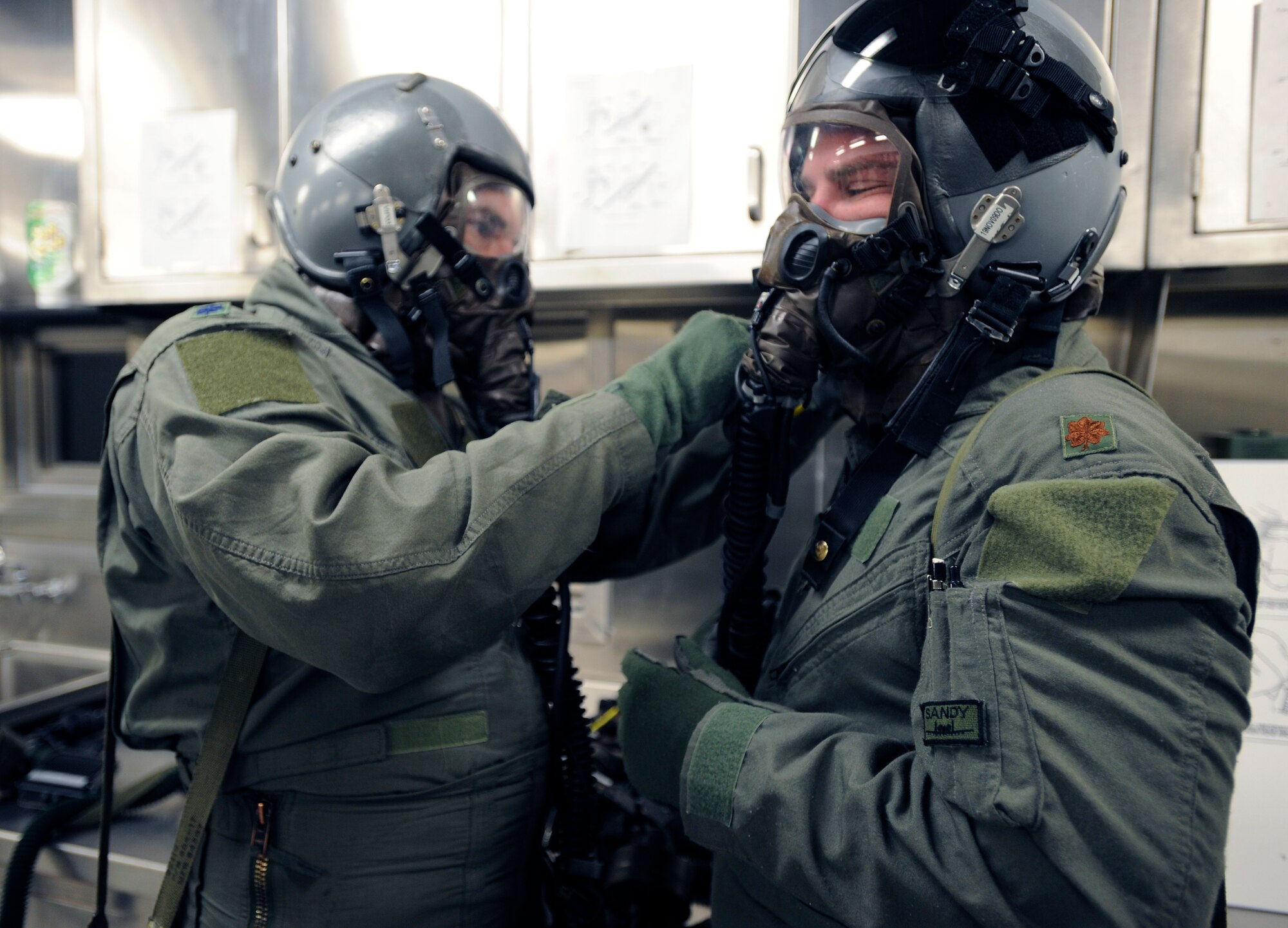 Lt. Col. Stephen Renner helps Maj. Jeffrey Ferguson properly secure his helmet before going through a simulated decontamination scenario at the 25th Fighter Squadron during exercise Beverly Midnight 09-02 on Osan Air Base, Nov. 2. (U.S. Air Force photo/Senior Airman Stephenie Wade)