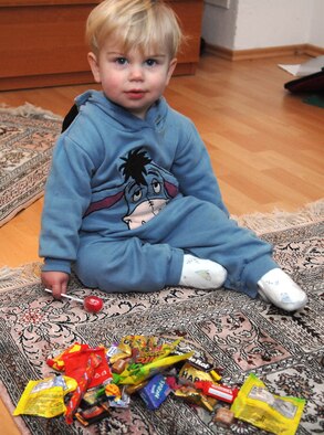 Hayden Michael Voss, son of Tech. Sgt. Michael Voss, 86th Airlift Wing public affairs, checks through his candy after trick-or-treating, Oct. 31, 2009. This year many of the housing areas on Ramstein Air Base, as well as local German communities, were filled with the more than 54,000 Kaiserslautern Military Community servicemembers enjoying Halloween. (U.S. Air Force photo by Tech. Sgt. Michael Voss)