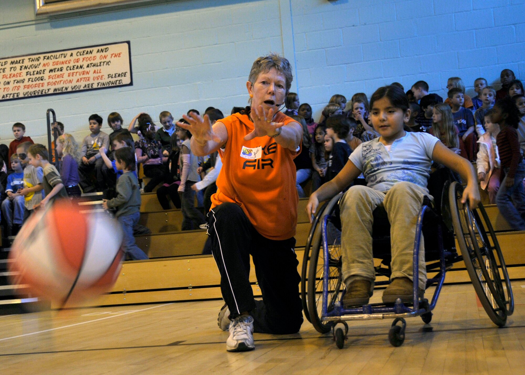 Jill Anderson, Bury Bombers coach, teaches the proper bounce pass to Alyssa, 3rd grader, during a hands-on demonstration of wheel chair basketball techniques at RAF Lakenheath, England Oct 27. Anderson has been coaching wheelchair basketball for 14 years. (U.S. Air Force photo/Airman 1st Class Eboni knox)