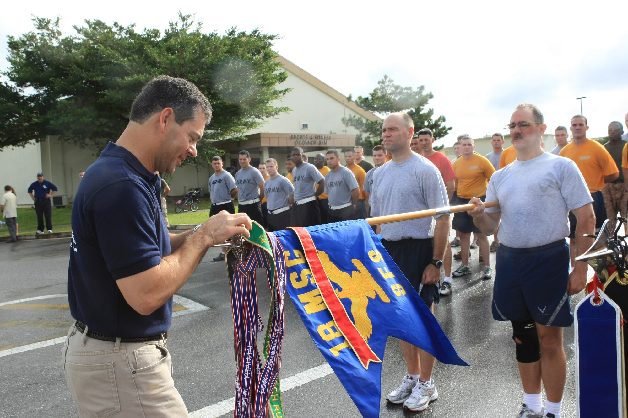 Brig. Gen. Ken Wilsbach, 18th Wing commander, ties a ribbon on the Special Olympics Torch Sat. Oct. 31, 2009 at Kadena Air Base, Japan. The general participated in the Special Olympics Torch Run which signifies the kick-off to the 2009 games which will be held Nov. 14 at Kadena. (Photo courtesy of Chip Steitz)  
