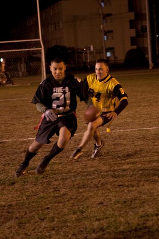 Five-O running back Kevin Ruidiaz attempts to evade a 242 Bats defensive lineman in hot pursuit during an intramural flag football game at the Northside football field here Nov. 2. Ruidiaz managed to escape and get a much needed first down for Five-O in the closing minutes of the game.