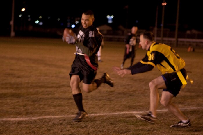 Five-O running back Kevin Ruidiaz narrowly jukes a 242 Bats defensive lineman to get a first down during an intramural flag football game at the Northside football field here Nov. 2. Five-O dominated the pre-season but has already lost one game during the regular season and barely managed to defeat the Bats 17-12.