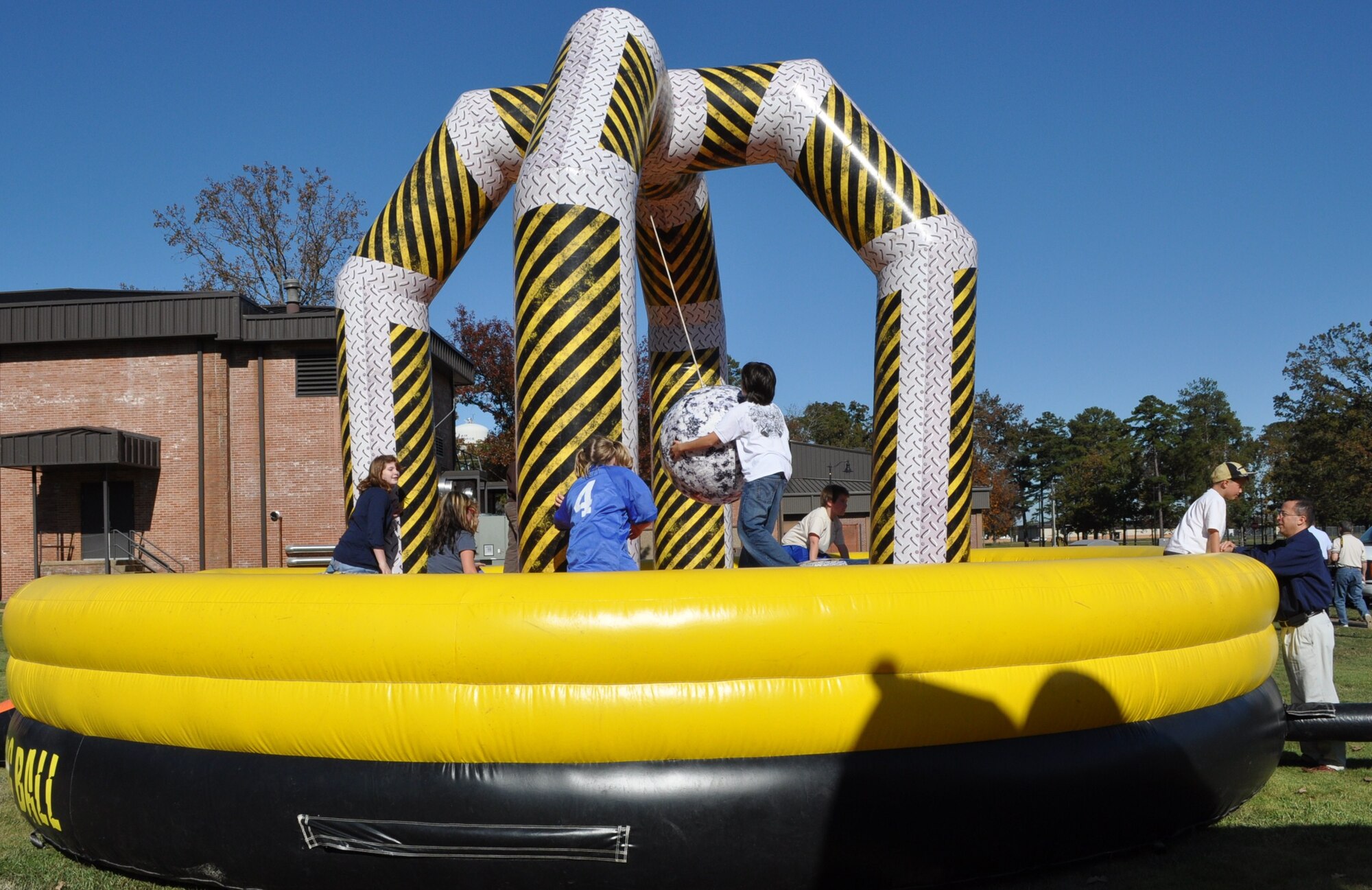 Chaplain (Capt.) Rick Montoya, 14th Flying Training Wing chaplain and Year of the Air Force Family project officer, offers “encouragement” to children playing on inflatable jumpers during Columbus AFB’s Year of the Air Force Family kick off Sports Day Nov.1. Over 140 BLAZE Team families helped kick off 14th FTW’s YotAFF week. (U.S. Air Force photo/Sonic Johnson)