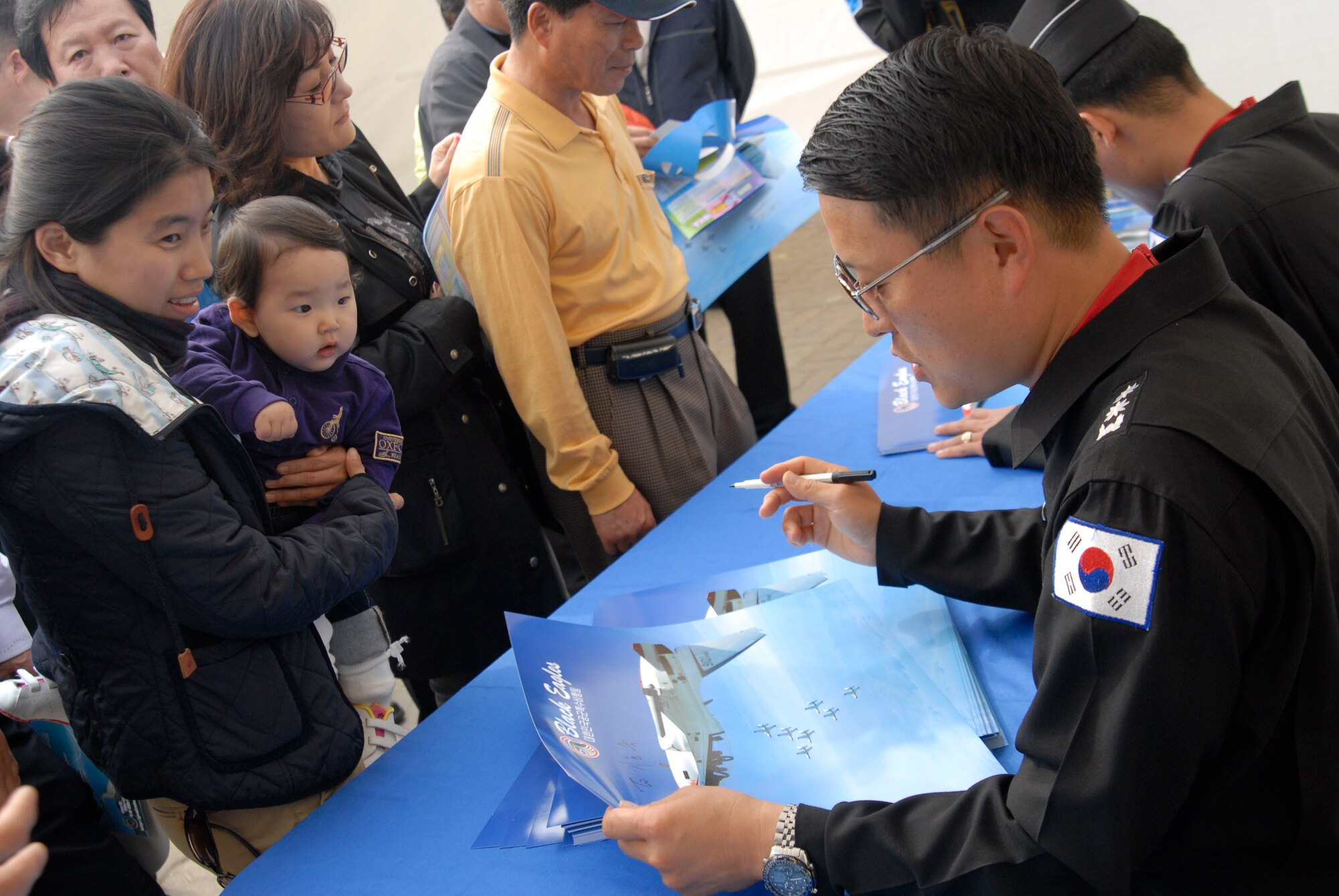 KUNSAN AIR BASE, Republic of Korea -- A Korean mom gets an autograph for her daughter from a Republic of Korea Air Force Black Eagle Pilot during the Gunsan Saemangeum Airshow in Gunsan City. The City of Gunsan, the 8th Fighter Wing and the Republic of Korea Air Forces' 38th Fighter Group hosted the air show, Oct. 31. (U.S. Air Force photo/Staff Sgt. Darnell T. Cannady)