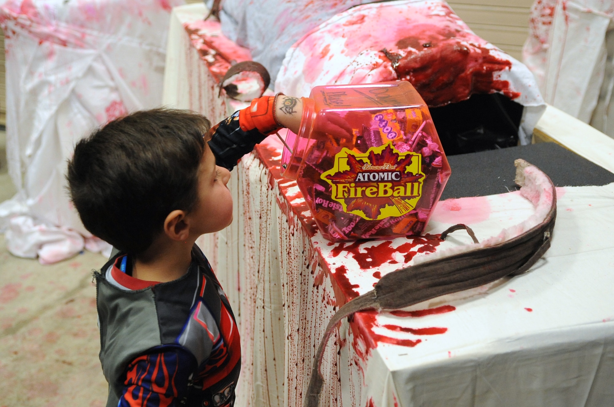 BUCKLEY AIR FORCE BASE, Colo. -- A young guest at the 460th Civil Engineer Squadron Halloween "Slaughter House" braves the gore and terror for a well-earned piece of candy. The 460th CES hosted the haunted house for military members and their families in late October. (U.S Air Force photo by Airman 1st Class Paul Labbe)