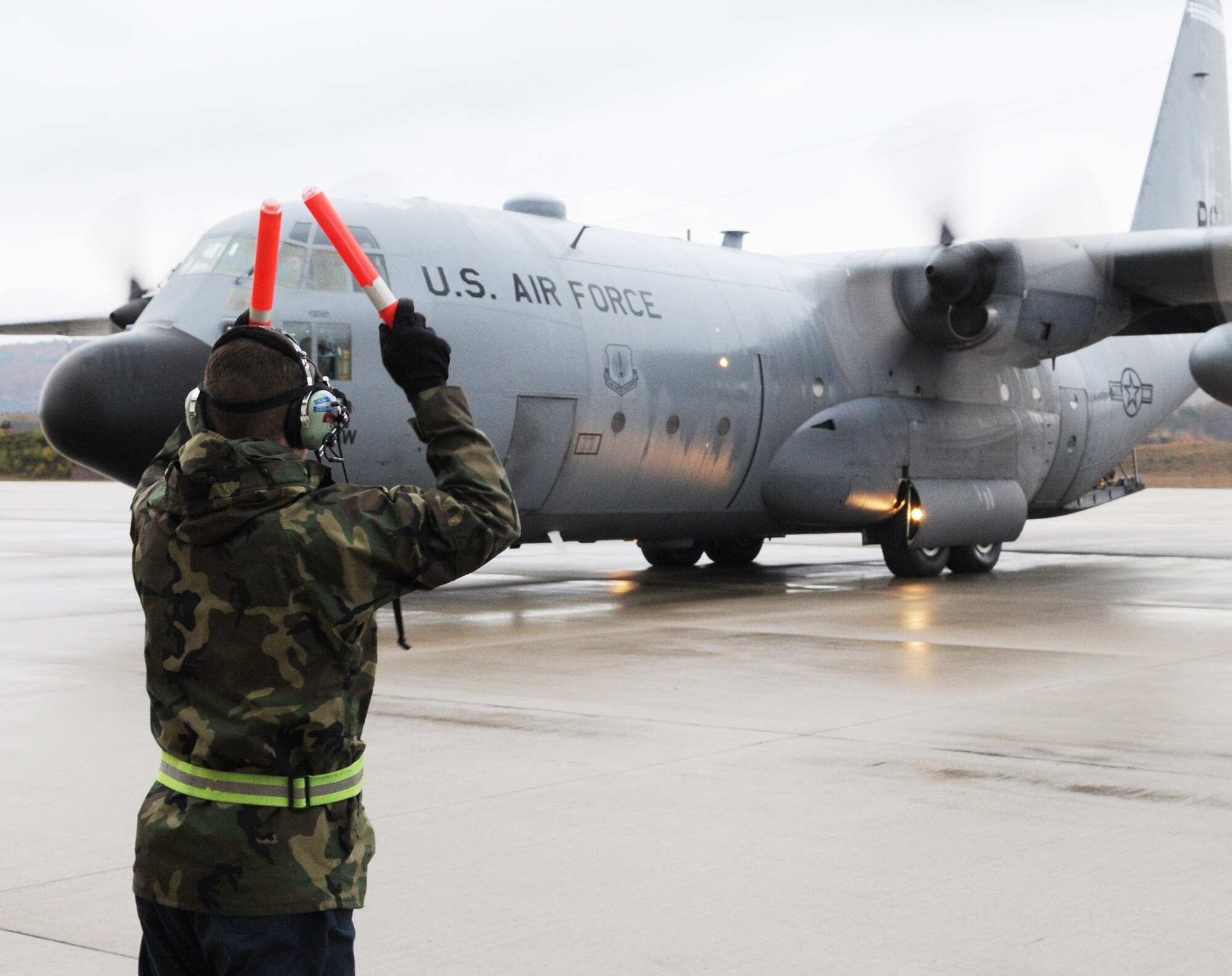 Senior Airman Jason Ricke, an 86th Aircraft Maintenance Squadron crew chief at Ramstein Air Base, Germany, marshals last C-130E Hercules onto the flight line for departure Nov. 2, 2009. The E-model Hercules aircraft have provided more than 40 years of airpower to bases in the United States Air Forces in Europe, and are being replaced by the newer C-130J Super Hercules as part of revitalizing the Air Force fleet. (U.S. Air Force photo/Airman 1st Class Caleb Pierce)