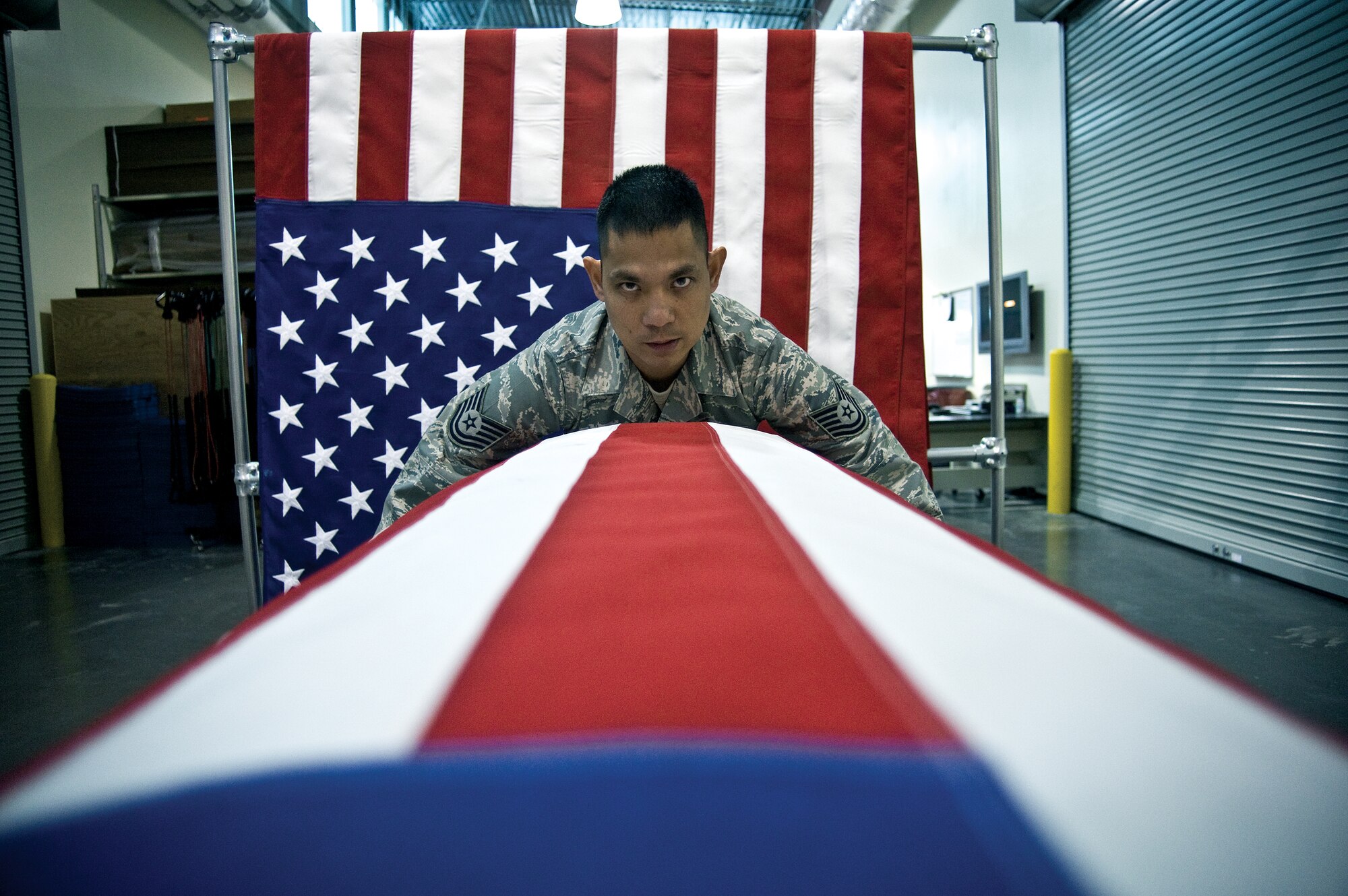 Tech. Sgt. Willard Rico tightens a U.S. flag over a casket in practice for a dignified transfer of remains. The AFMAOC is the Defense Department's only joint-service mortuary in the continental United States. (U.S. Air Force photo/Staff Sgt. Bennie J. Davis III)