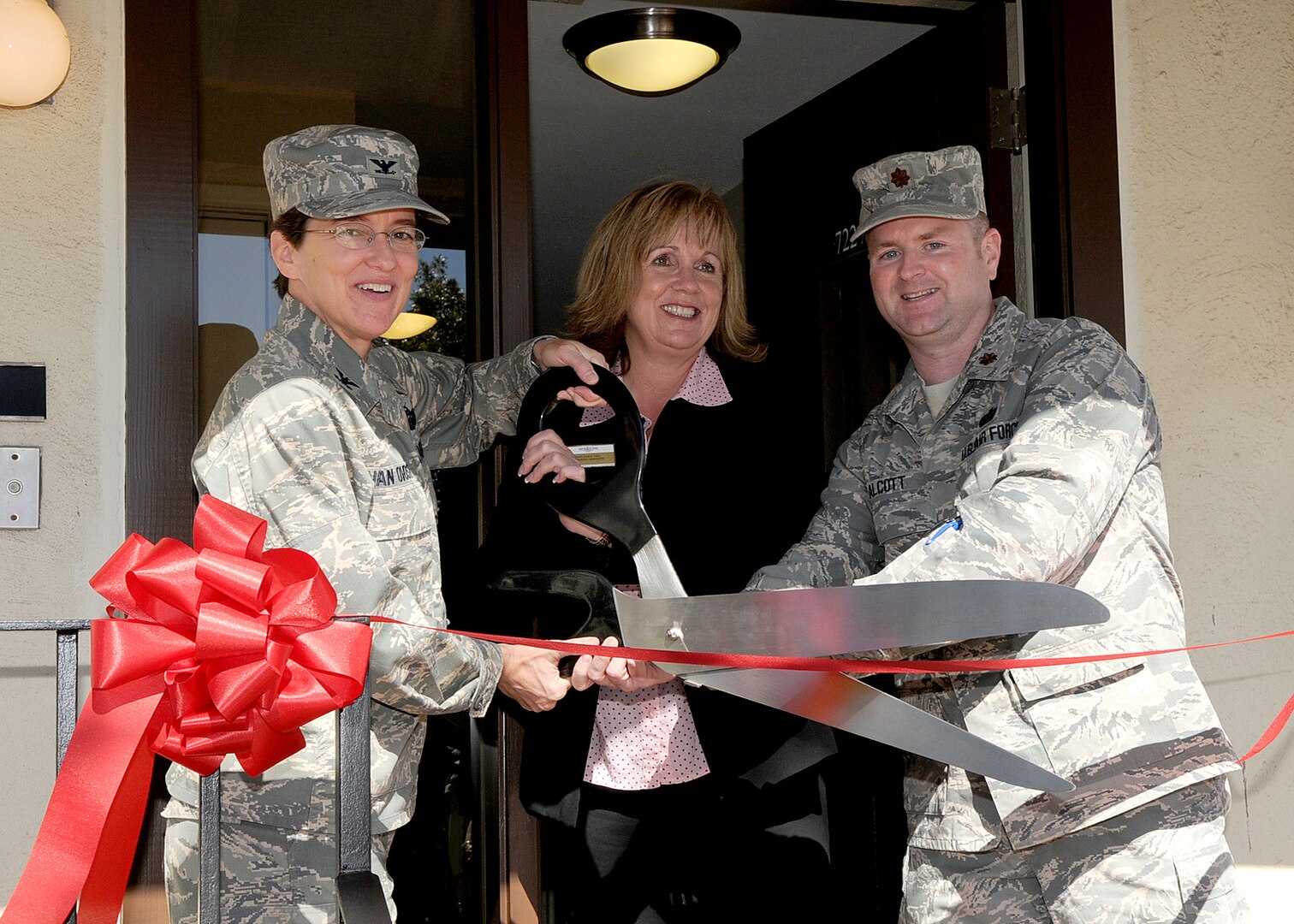 Col. Jacqueline Van Ovost, 12th Flying Training Wing commander, Mary Eddy, 12th Force Support Squadron lodging manager, and Maj. Todd Alcott, Air Force Lodging chief, cut the ribbon to officially open a new Temporary Lodging Facility at Randolph Air Force Base Nov. 3. (U.S. Air Force photo by David Terry)