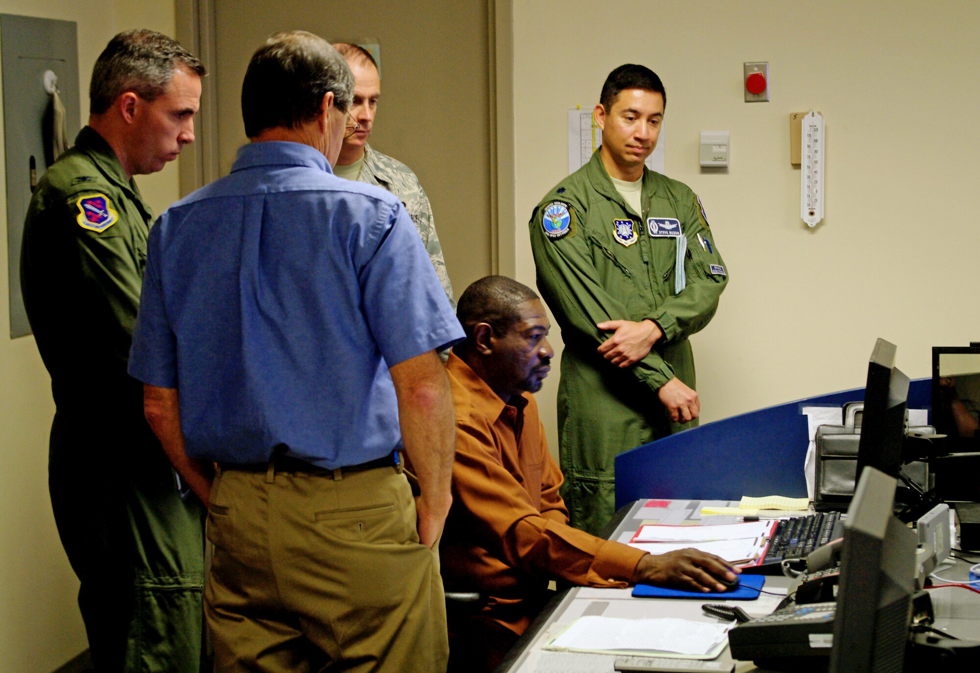 Senior orbital analyst Wayne Slater, 20th Space Control Squadron Detachment 1, Dahlgren, Va., walks Col. Stephen Whiting, 21st Space Wing commander (far left), and Chief Master Sgt. Tim Omdal, 21st Space Wing command chief, through the process of correlating space debris back to a known satellite. The wing leaders visited the site Oct. 20. Breakup and collision avoidance processing are two key ingredients that allow Detachment 1 to conduct precise command and control of the space surveillance network and maintain space situational awareness. Detachment 1 is one of the 21st Space Wing’s geographically separated units providing space situational awareness around the globe. (Air Force photo by Teresa Watkins)