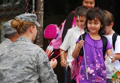 Stacey Scott takes a glow-in-dark necklace to wear for staying visible during Halloween from Senior Airman Meagan Bustillo at the Lamb's Elementary School gate here Oct. 30. The 437th Airlift Wing Safety Office performs annual safety sendoffs for local students to remind them to stay safe while trick-or-treating. Airman Bustillo is a safety apprentice with the 437 AW Safety Office and Stacey is the daughter of Master Sgt. Donald Scott who is with the 437th Maintenance Operations Squadron. (U.S. Air Force photo/Staff Sgt. Daniel Bowles)