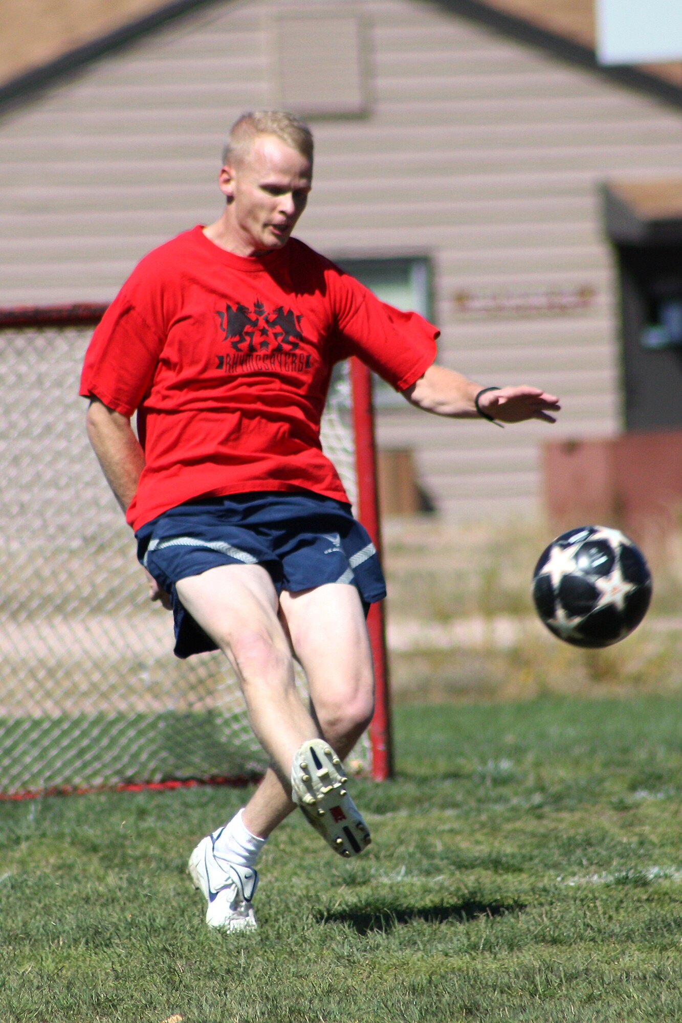 Staff Sgt Robert Magarrell, 21st Civil Engineer Squadron, kicks the ball to a teammate during a lunch-time soccer pick-up game. A group of dedicated soccer players meets Mondays, Wednesdays and Fridays behind the fitness center to keep their skills sharp. (U.S. Air Force photo by Lisa Deem)