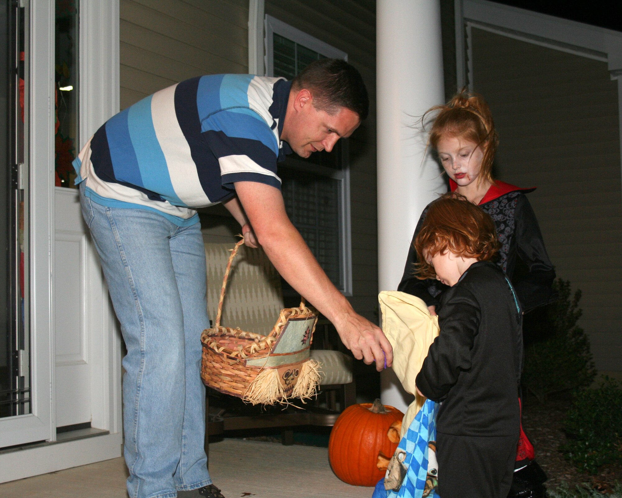 Alexis and David Wright, children of Master Sgt. Chris Wright, 87th Security Forces Squadron, rake in the candy on Halloween night as trick-or-treaters blanketed base housing.  McGuire’s invitation to trick-or-treaters is a yearly affair, always popular with the younger crowd. (U.S. Air Force photo/Kim Wright)