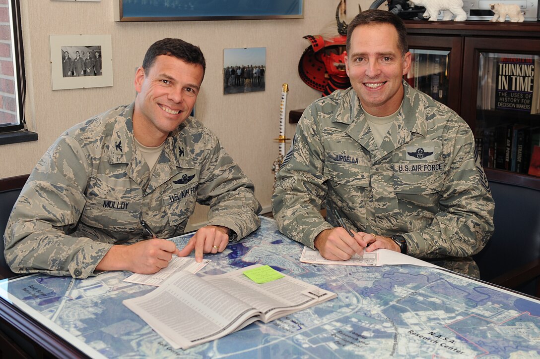 LANGLEY AIR FORCE BASE, Va. -- Col Matt Molloy, 1st Fighter Wing commander, and Chief Master Sgt Kevin Jurgella, 1st FW command chief, sign checks to donate money to Langley’s 2009 Combined Federal Campaign here Nov. 3. The program provides federal employees with an opportunity to support local, national and international charities. This year team Langley is looking to raise more than $436,000, the CFC runs from Oct. 5 to Nov. 20. (U.S. Air Force photo/Airman 1st Class Gul Crockett)

