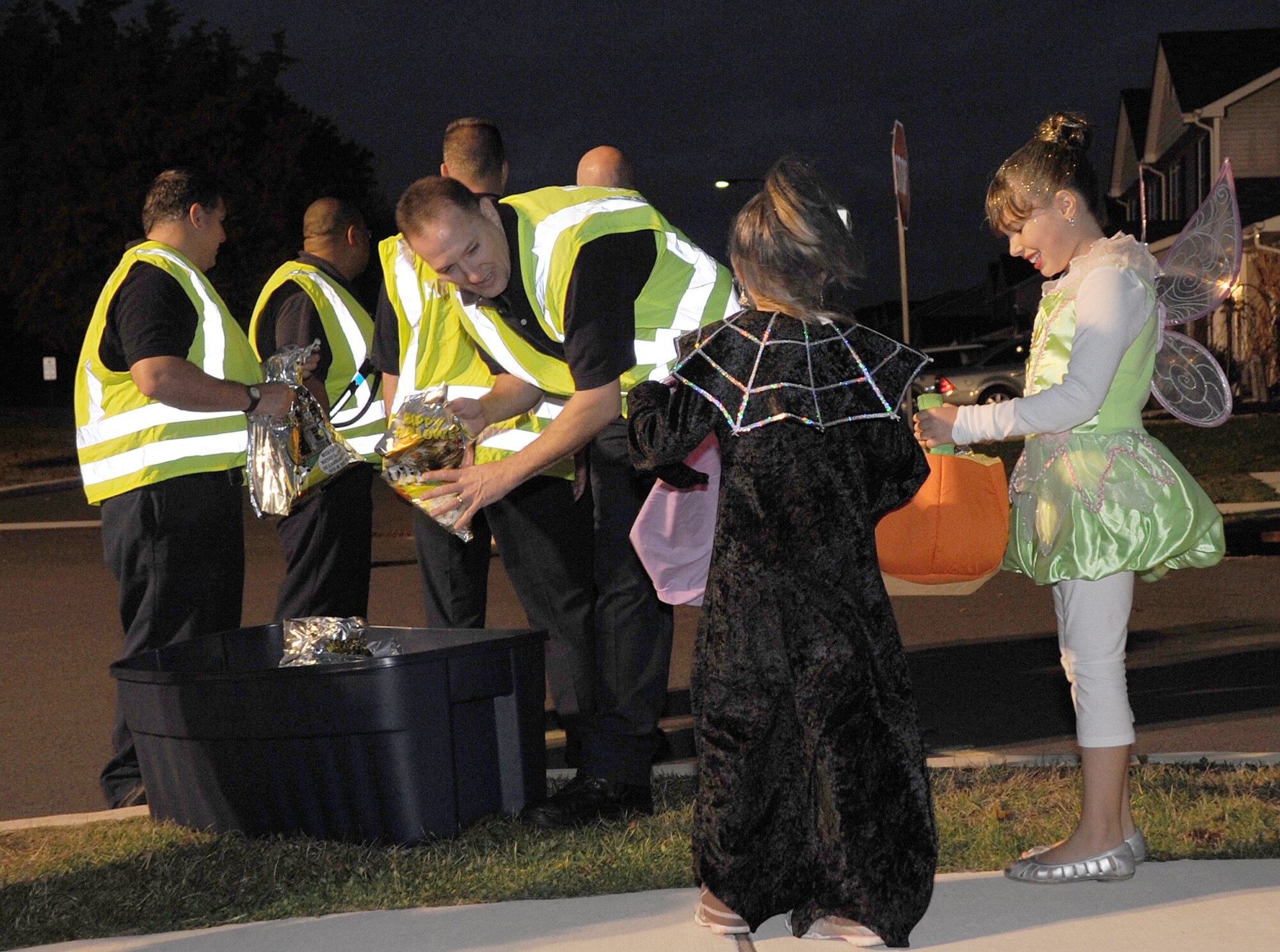 Members of the Joint Base McGuire-Dix-Lakehurst fire department hand out bags of goodies in the Garden Terrace housing area during trick-or-treat hours Saturday at on Dix.  Children dressed up and stepped out to celebrate Halloween under the watchful eyes of the fire department, security forces and the volunteers of the Pumpkin Patrol. (U.S. Air Force photo/Staff Sgt. Danielle Johnson)