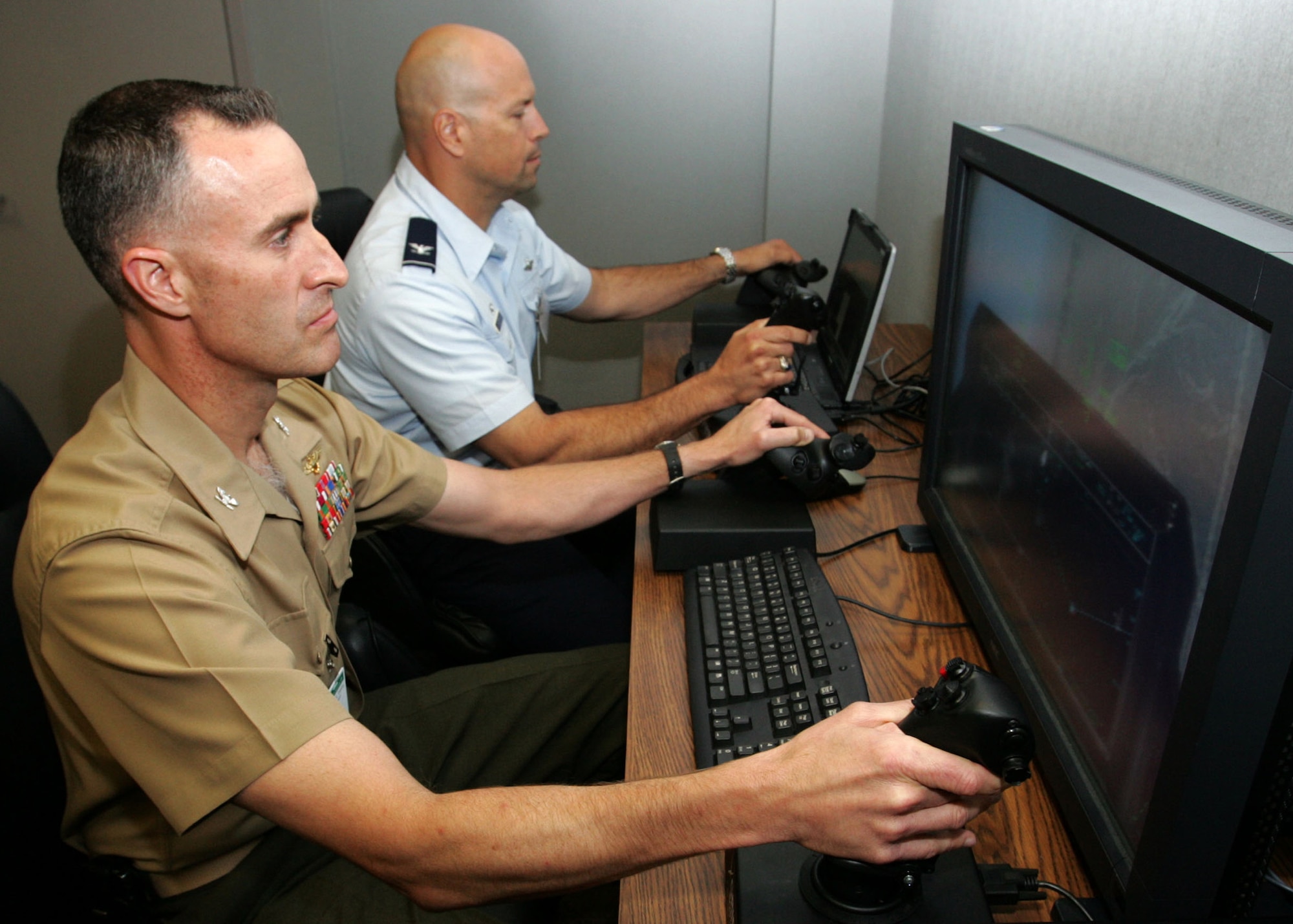 EGLIN AIR FORCE BASE, Fla. -- Marine Corps Col. David A. Robinson, Marine Aircraft Group 31 commander, and U.S. Air Force Col. David Hlatky, 33rd
Fighter Wing commander, here, experience the capabilities of the a F-35 Joint Strike Fighter Training Device during their recent visit to Lockheed Martin in Orlando, Fla.
(courtesy photo)
