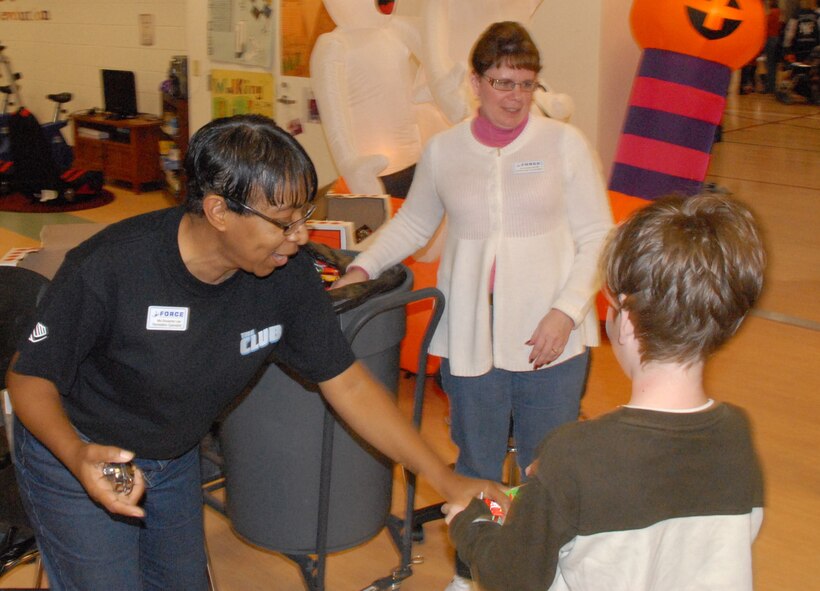 (Left) Roxanne Lee, Youth Center recreational specialist, and Bonnie McGill, Youth Center school age coordinator, hand out candy to children at the Youth Center during the Harvest Festival Oct. 30.  The Harvest Festival was the kick-off event for the Year of the Air Force Family.  For more information on Year of the Air Force Family, visit http://www.af.mil/yoaff.  (U.S. Air Force photo/Staff Sgt. Chad Padgett)