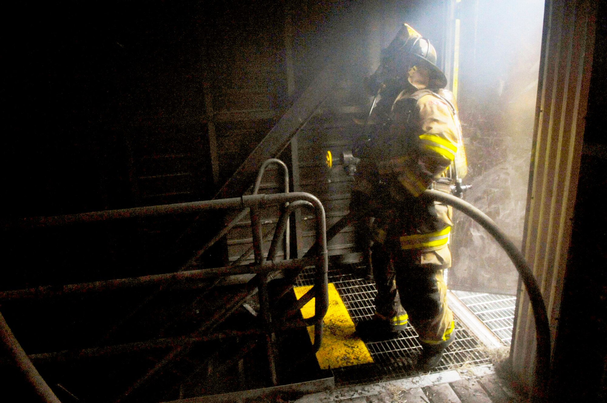 District of Columbia firemen recruit waits with hose in hand for orders to move to his next position. The training facility here on Joint Base Andrews allowed D.C. fire school instructors to evaluate a team?s ability to move quickly and effectively from ground level, to multiple levels, in a building in order to properly extinguish fires.  (U.S. Air Force photo/Senior Airman Steven R. Doty)