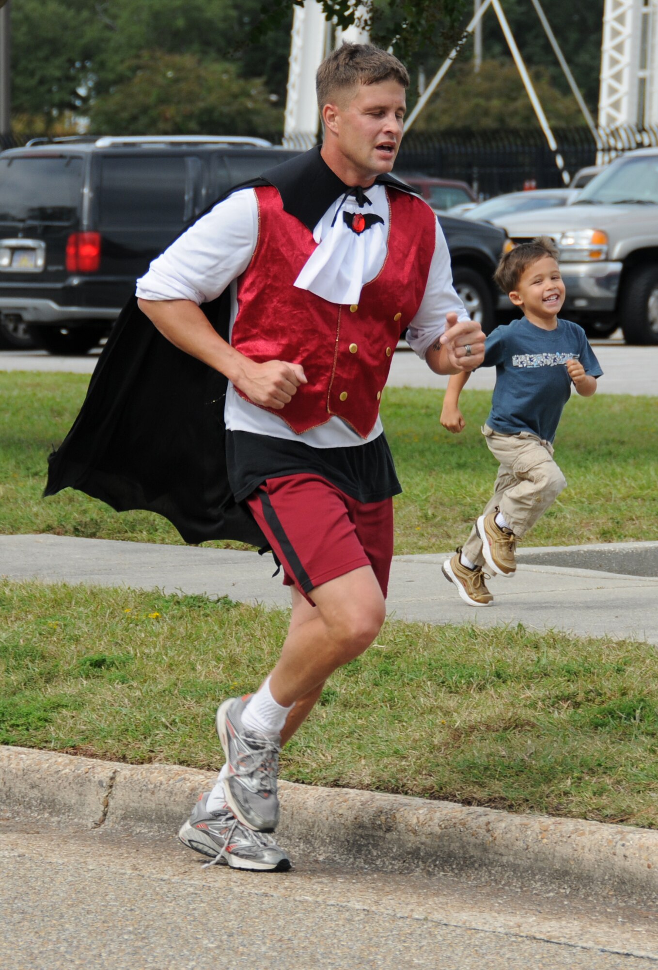 Tech. Sgt. Jeremy Sedlak, in vampire attire, is shadowed by his 4-year-old son, Dylan, as he nears the finish line of the 5-kilometer Costume Fun Run Oct. 28.  Sergeant Sedlak, 338th Training Squadron, was the first male finisher with a time of 23 minutes, 4 seconds.  (U.S. Air Force photo by Kemberly Groue)