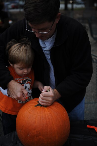Keith Rands, retired avionics technician, helps his grandson, Gavin, age 2, cut the stem from his pumpkin during the community center's pumpkin carving event on Seymour Johnson Air Force Base, N.C., Oct. 29, 2009. The base's "spooky" activities kicked-off Oct. 28 to include a Halloween trail, a pumpkin patch at the child development center, Halloween Block Party and trick-or-treating. (U.S. Air Force photo/Senior Airman Ciara Wymbs)