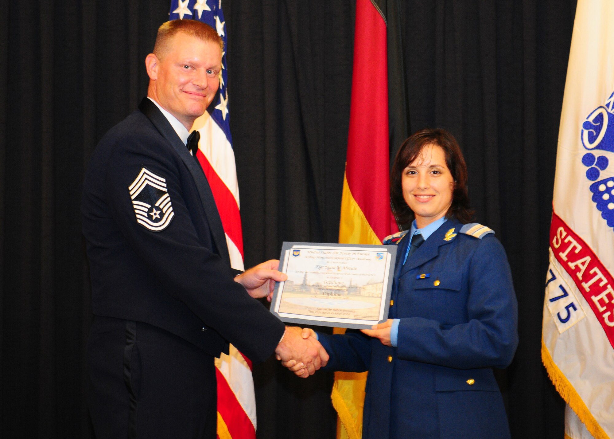 Chief Master Sgt. David Lawrence, Kisling NCO Academy commandant, presents a graduation certificate to Romanian air force Plutonier (technical sergeant equivalent) Diana-Cristina Mireuta at the NCO Academy graduation, Oct 30.(U.S. Air Force photo/ Staff Sgt. Jocelyn Rich)
