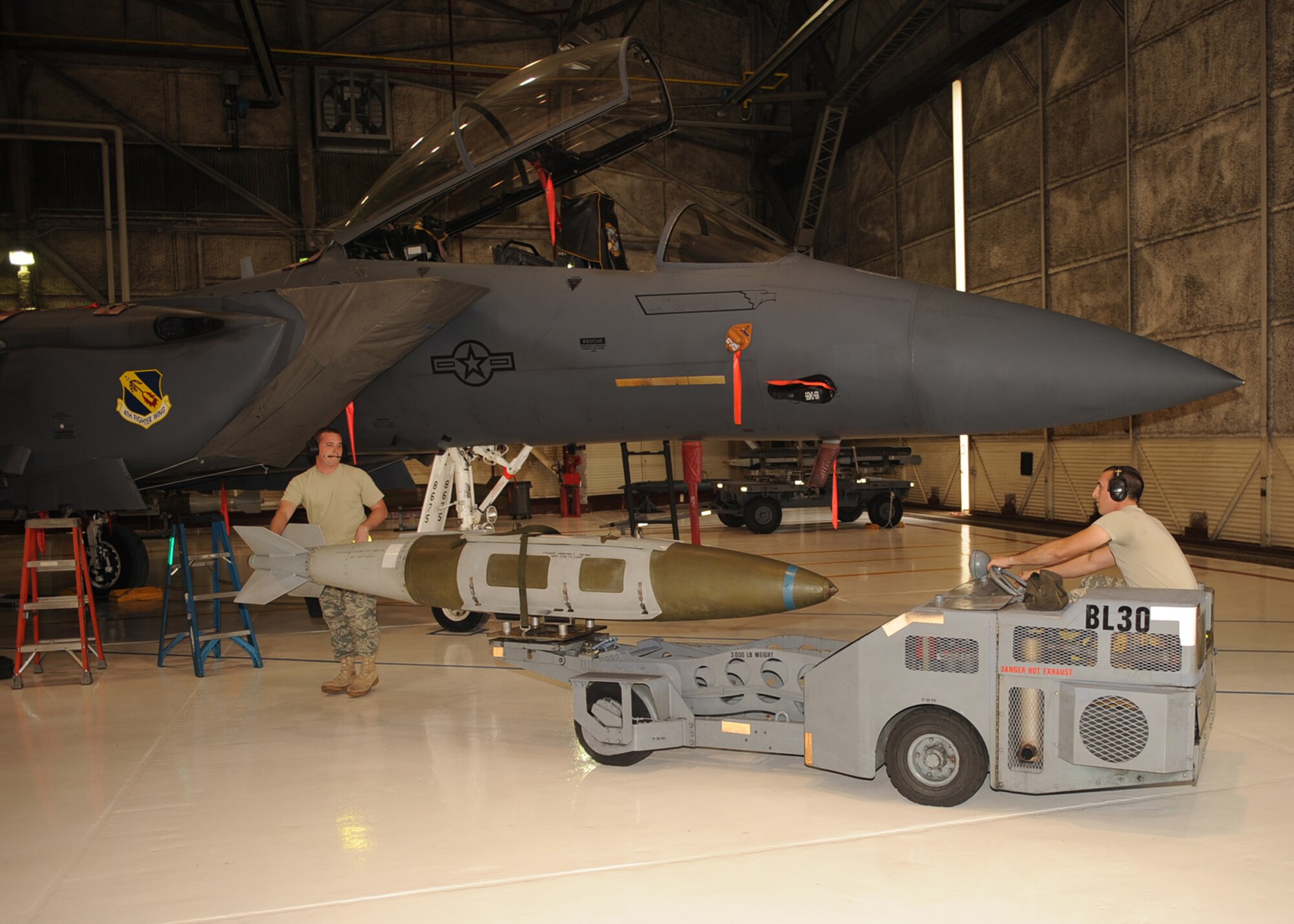 Senior Airman Shane Reinhold (right), drives a bomb lift truck holding a training guided bomb unit while Staff Sgt. Christopher Yones steadies the unit for placement during a weapons load crew competition on Seymour Johnson Air Force Base, N.C., Oct. 30, 2009. Airman Reinhold and Sergeant Yones are from the 336th Aircraft Maintenance Unit.  (U.S. Air Force photo/Senior Airman Ciara Wymbs)