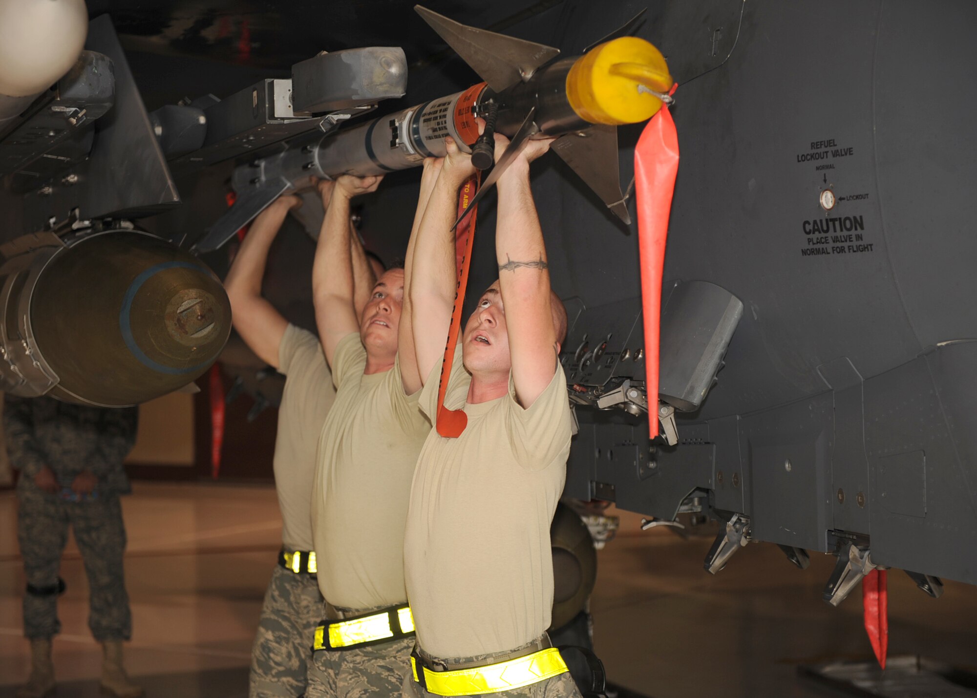 Weapon loaders from the 336th Aircraft Maintenance Unit attach a training air intercept missile to an F-15E Strike Eagle during a weapons load crew competition on Seymour Johnson Air Force Base, N.C., Oct. 30, 2009.  The competition evaluated weapons loading, general knowledge, composite tool kits, and included a dress and appearance inspection. (U.S. Air Force photo/Senior Airman Ciara Wymbs)  