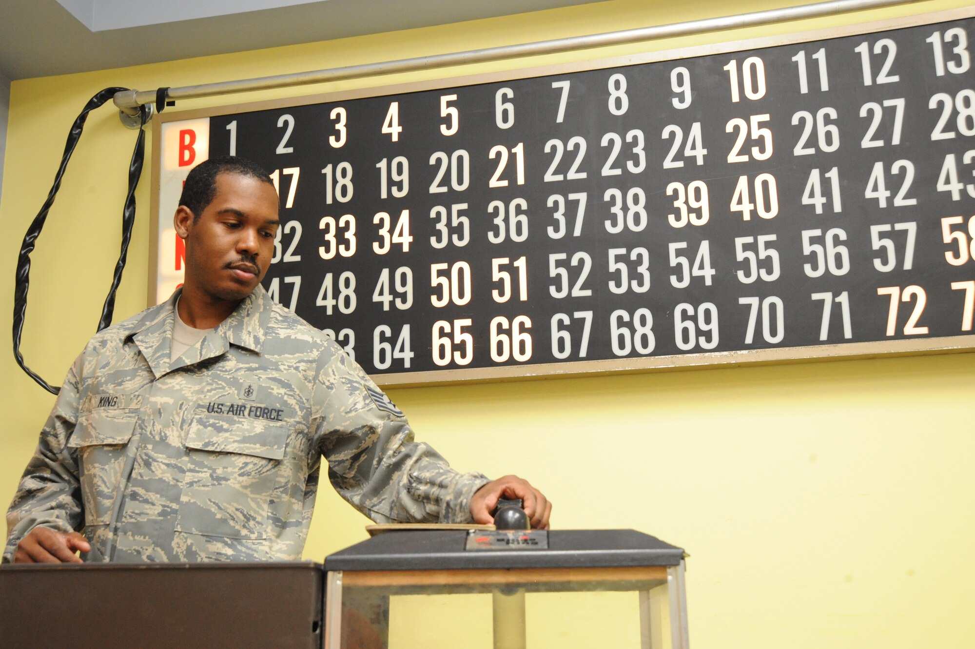 Staff Sgt. Julius King, 22nd Force Support Squadron, pulls a ball from a bingo number dispenser, Oct. 29, 2009, during a bingo game at the Robert J. Dole Department of Veterans Affairs Medical and Regional Office Center, Wichita, Kan. More than 15 Team McConnell members attended the event. (U.S. Air Force photo by Tech. Sgt. Chyrece Campbell)