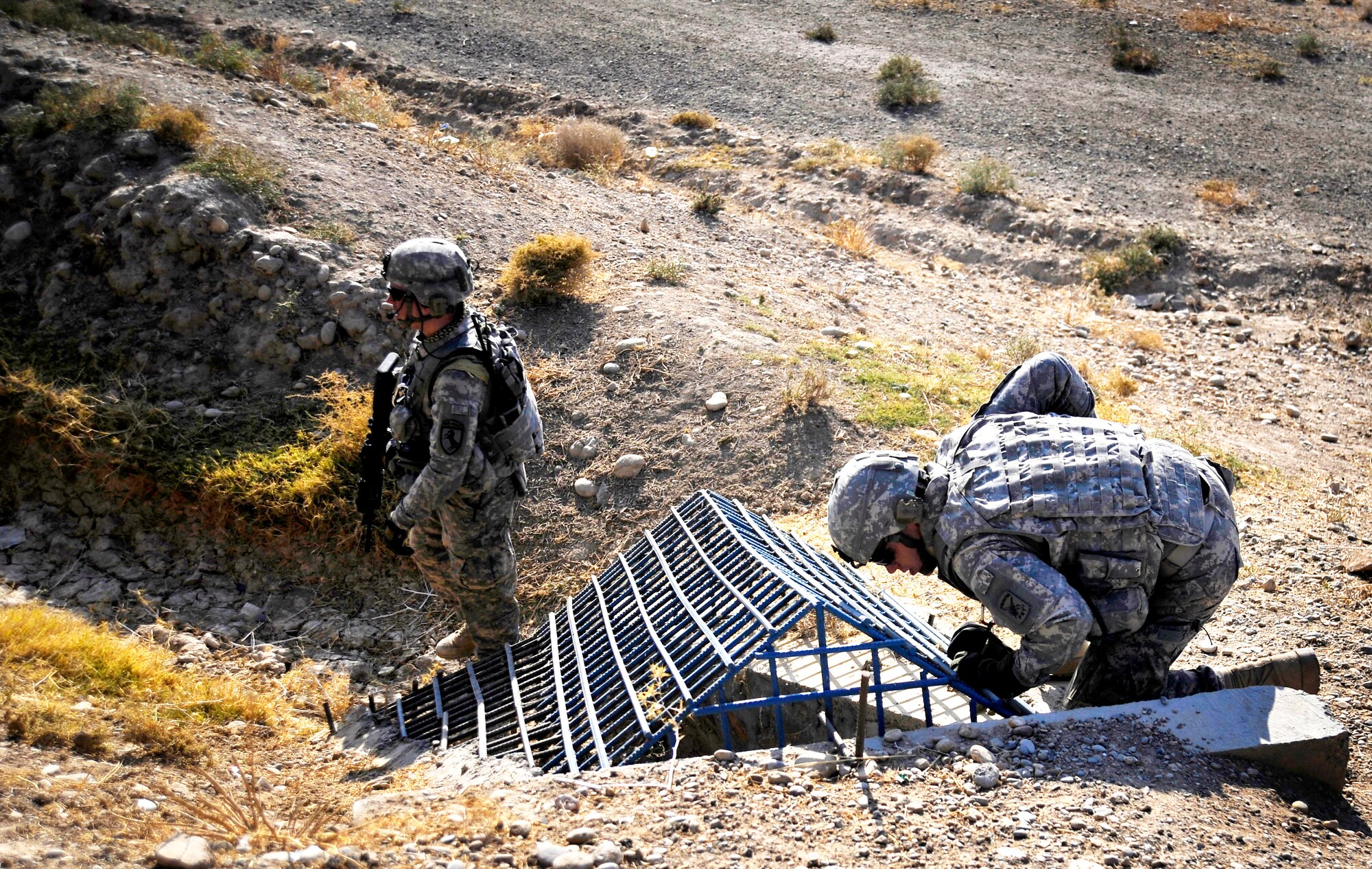 Army Sgt. William Brinkley stands guard while Capt. Rick Vermillion inspects a bridge for improvised explosives devices, damages or traces of tampering Oct. 23, 2009, in Zabul Province, Afghanistan. The inspections provide safety to the people of Zabul as well as coalition forces while traveling. Sergeant Brinkley is a security forces Soldier assigned to the Provincial Reconstruction Team Zabul, and Captain Vermilion is a PRT engineer. (U.S. Air Force photo/Staff Sgt. Angelita Lawrence) 
