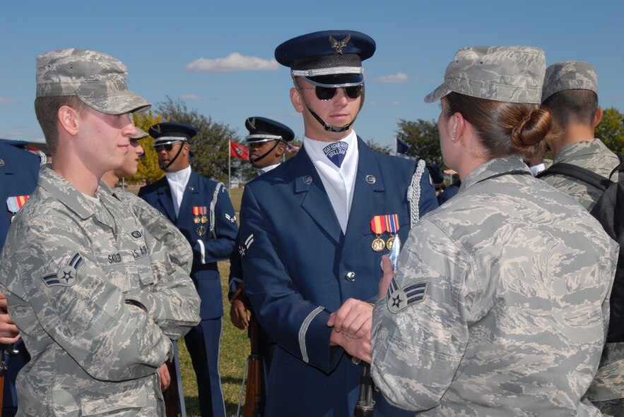 GOODFELLOW AIR FORCE BASE, Texas -- Airman 1st Class Thomas Sadler, 17th Communications Squadron, and Senior Airman Jeanice Smith, 316th Training Squadron instructor, speak with Airman 1st Class Hunter Overaton, U.S. Air Force Honor Guard Drill Team, following a performance by the drill team, Oct. 30, 2009. The Drill Team is the traveling component of the U.S. Air Force Honor Guard and tours worldwide representing all Airmen while showcasing Air Force precision and professionalism. (U.S. Air Force photo/Staff Sgt. Laura R. McFarlane) 