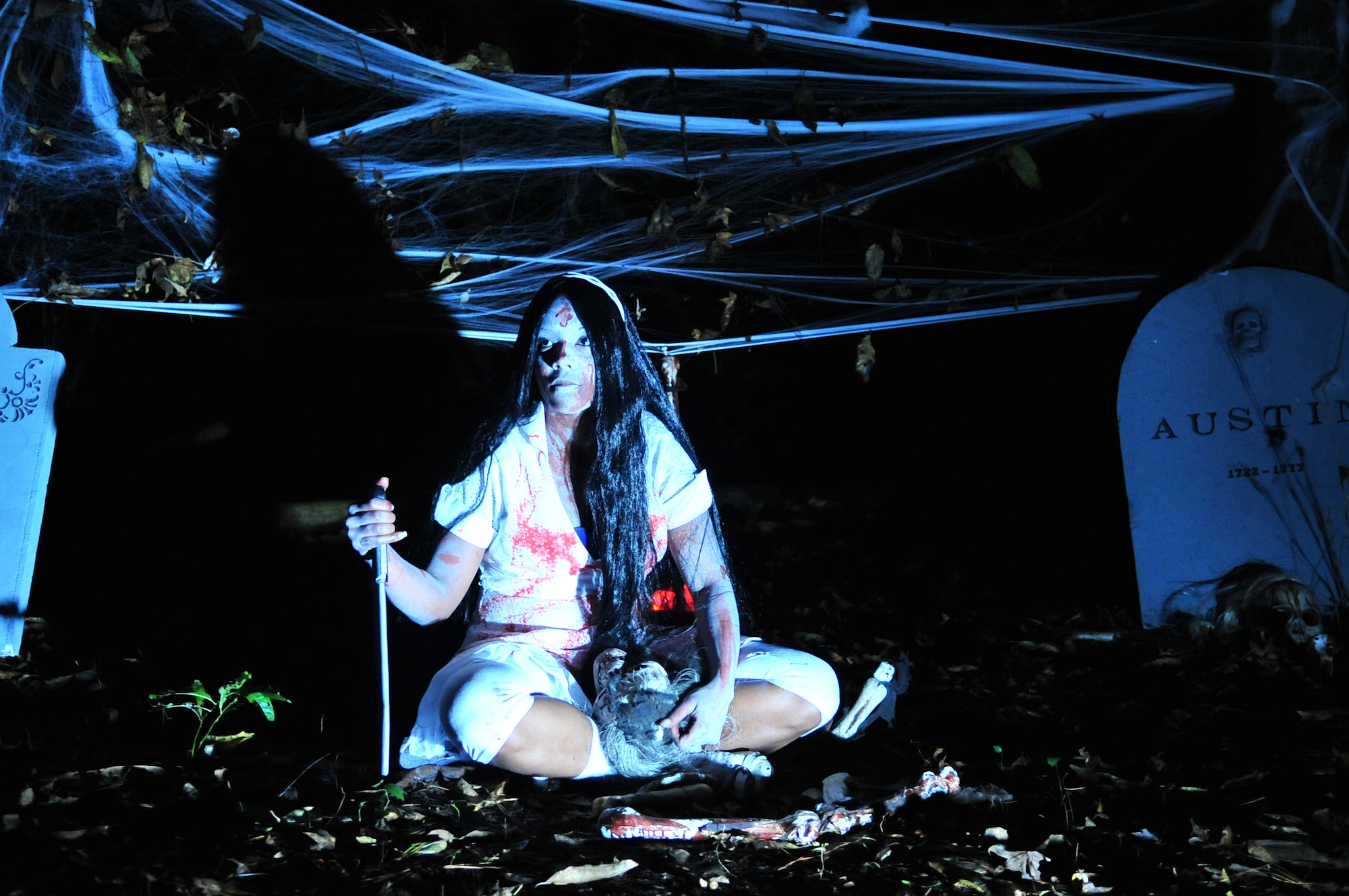 Senior Airman Raquel Baldwin, 4th Communications Squadron knowledge operations publications journeyman, waits for a group of patrons to scare during the 4th CS Haunted Trail in Kimpo Park on Seymour Johnson Air Force Base, N.C., Oct. 28, 2009. Every year, the 4th CS clears a path through the woods and invites other base squadrons to construct haunting scenes to scare people in true Halloween fashion. (U.S. Air Force photo/Airman 1st Class Rae Perry)