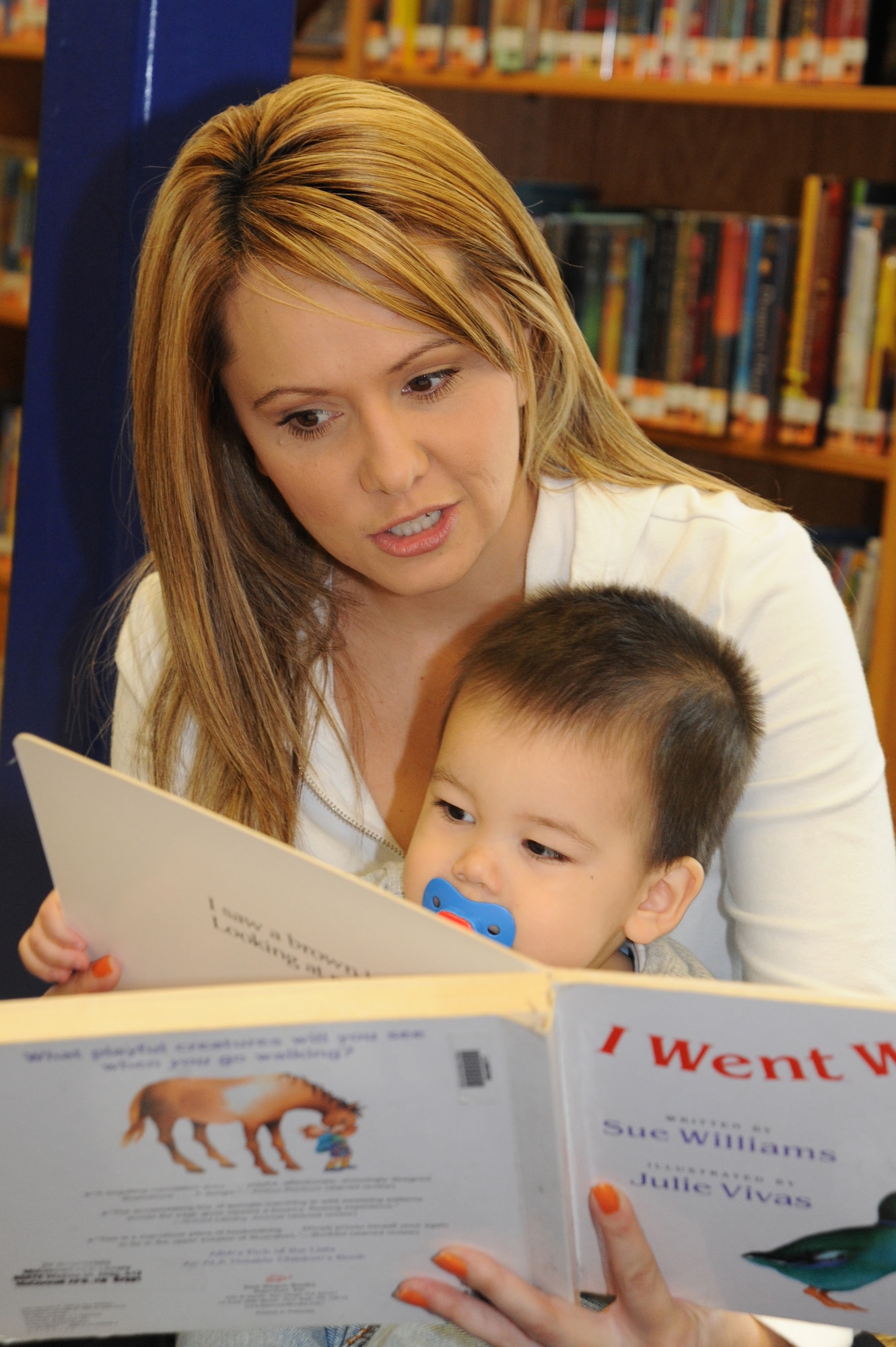 Naomi Gonzales reads to her son Isaiah, 1, during Books and Babies hosted by the Parents as Teachers Heroes at Home program at the library on McConnell Air Force Base, Kan., Nov. 2, 2009. Team McConnell family members read and sang songs to their children during the Books and Babies event. (U.S. Air Force photo by Tech. Sgt. Chyrece Campbell)