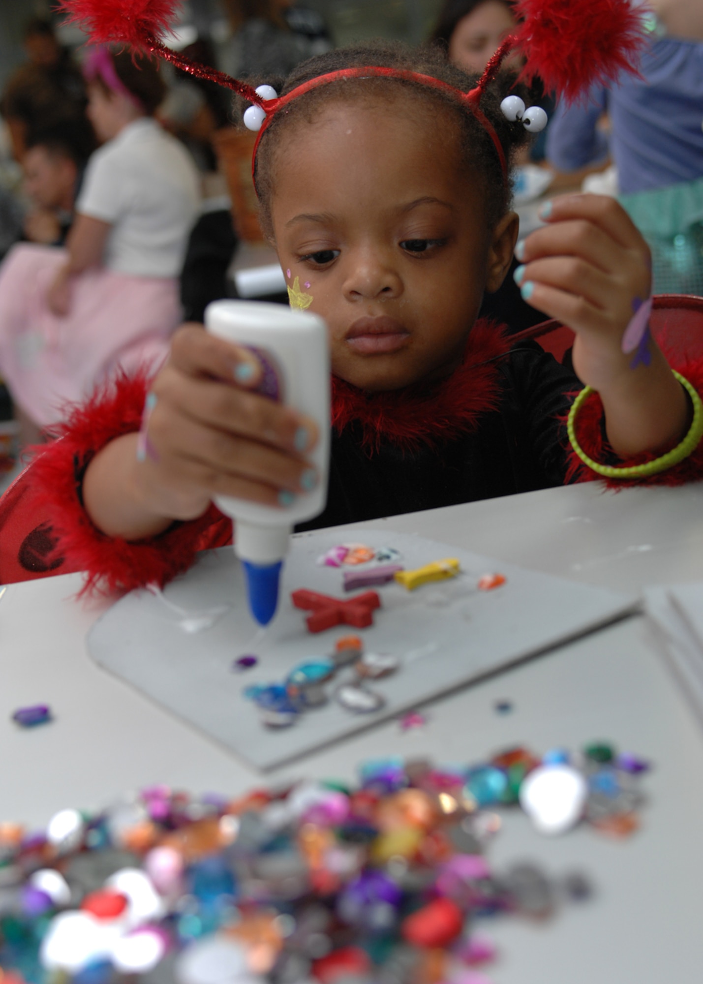 Janelle Corpening, daughter of Staff Sgt. Terence Corpening, 39th Communications Squadron, glues jewels on a shield at the chapel harvest festival Saturday, Oct. 31, 2009, at Incirlik Air Base, Turkey. The theme of the evening was ‘Walking through the Bible’ and was the church's alternative to secular Halloween celebrations. Over 300 people participated in arts and crafts and activities based on Bible stories. (U.S. Air Force photo/Staff Sgt. Lauren Padden) 