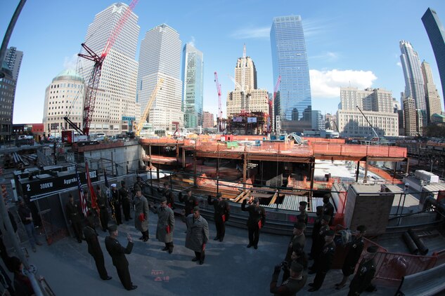 Buildings stand at the position of attention as Col. Mark J. Desens, Special Marine Air Ground Task Force 26 commanding officer, gives the oath of enlistment to Marines at  ground zero in New York City, Nov. 4, 2009. The Marines are in New York City for the commissioning of USS New York, which contains 7 1/2 tons of steel from the World Trade Center.
