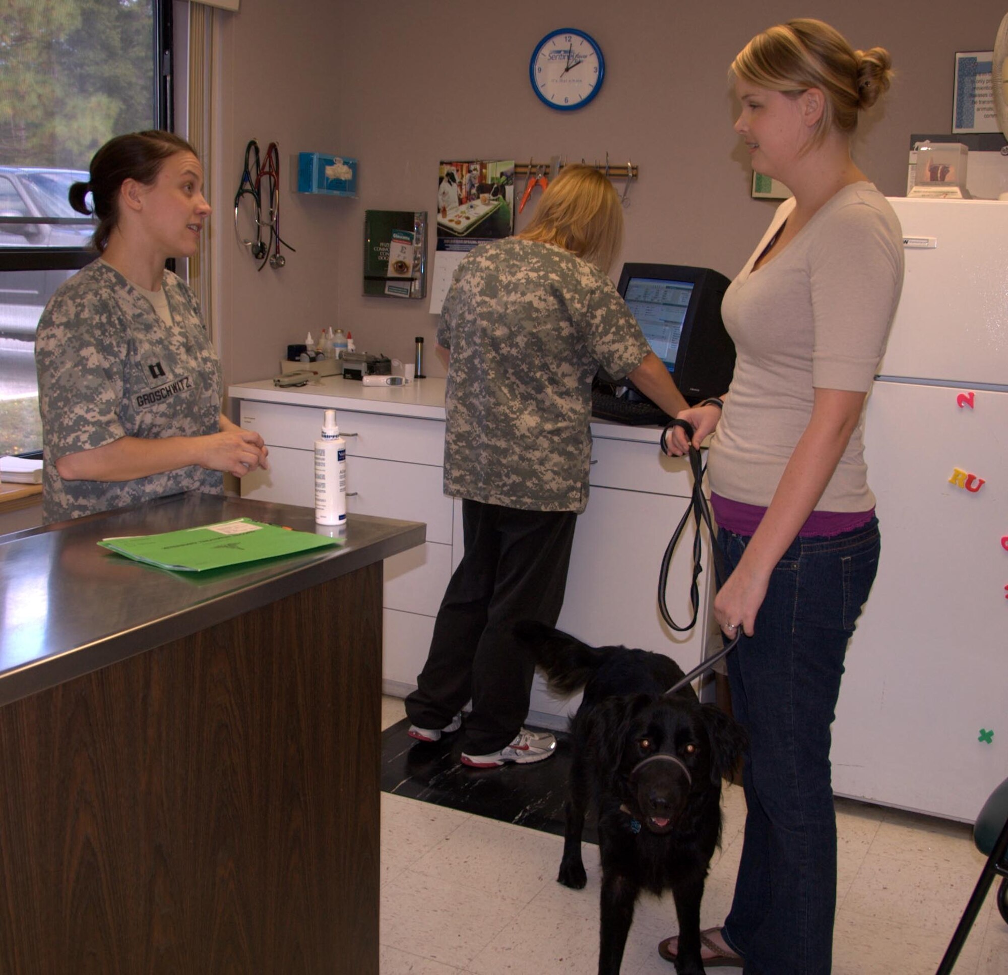 Army Captain Claire Groschwitz, 325th Fighter Wing Veterinarian discusses allergy treatment for Belle a two-year old lab mix with Camille Waldon, wife of Senior Airman Zachary Walden. (U.S. Air Force photo by: Major Veronica Kemeny)


