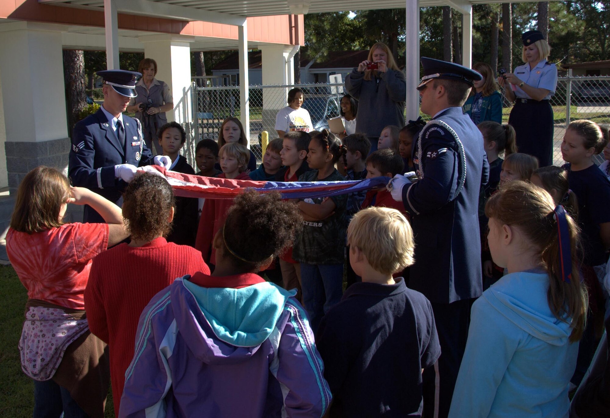 Senior Airman Gary Eaton and Airman First Class Blake Cooper from the 325th
Fighter Wing Honor Guard demonstrate proper American flag folding techniques
to Lynn Haven Elementary students Nov. 2.  The students are in charge of
raising and lowering the school flag each day. (U.S. Air Force photo by: Lt.
Col. Malcolm Kemeny)

