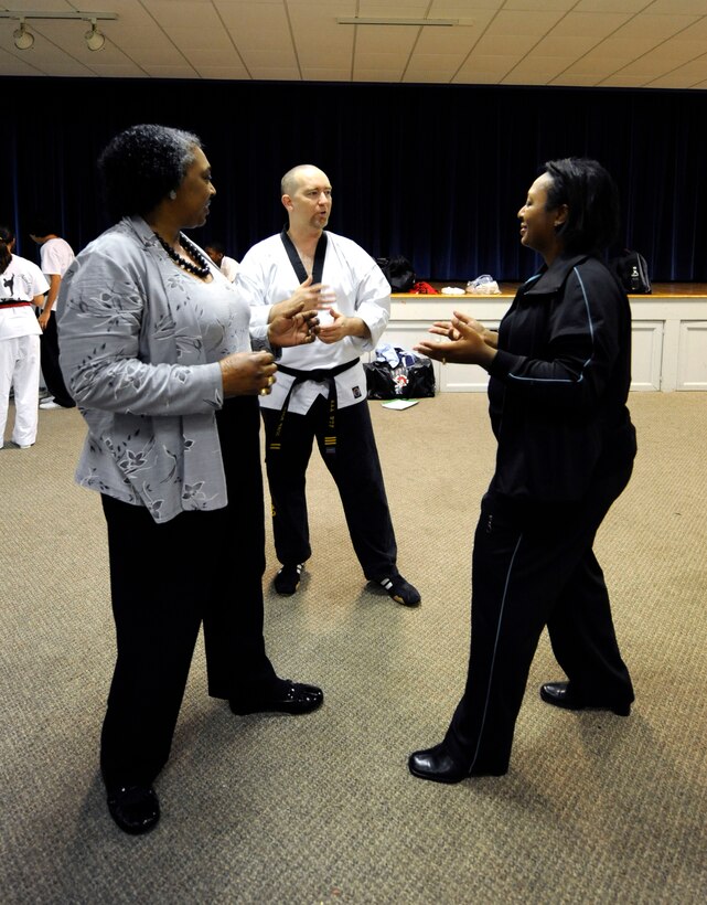 LANGLEY AIR FORCE BASE, Va. - Carol Shaw, Air Combat Command, and Cynthia Bush, 1st Force Support Squadron, receive directions from Doug Boyd, International Combat Hapikdo Federation instructor and third-degree black belt, Nov. 3. The Family Self-Defense Class, taught by trained black belts from the International Combat Hapikdo Federation, is one of many events held during Military Family Week, Nov. 1-7.  (U.S. Air Force photo/Senior Airman Dana Hill)
