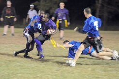 Coast Guard players remove the flag from Anthony Clay as he tries to move the ball down the field during an intramural flag football game held here Nov. 3. The 437th Security Forces Squadron defeated the Coast Guard 20-6. Clay is a member of the 437 SFS. (U.S. Air Force photo/Staff Sgt. Marie Brown)
