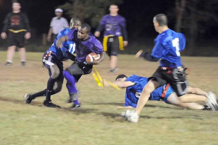 Coast Guard players remove the flag from Anthony Clay as he tries to move the ball down the field during an intramural flag football game held here Nov. 3. The 437th Security Forces Squadron defeated the Coast Guard 20-6. Clay is a member of the 437 SFS. (U.S. Air Force photo/Staff Sgt. Marie Brown)