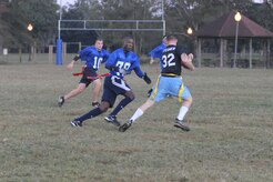 A member of the Coast Guard flag football team tries to remove the flag from Ross Stegner as he runs the ball on a punt return during an intramural flag football game here Nov. 3. The 437th Security Forces Squadron defeated the Coast Guard 20-6. Cook is a member of the 437 SFS. (U.S. Air Force photo/Staff Sgt. Marie Brown)