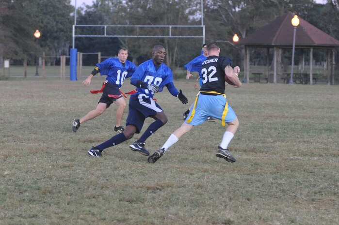A member of the Coast Guard flag football team tries to remove the flag from Ross Stegner as he runs the ball on a punt return during an intramural flag football game here Nov. 3. The 437th Security Forces Squadron defeated the Coast Guard 20-6. Cook is a member of the 437 SFS. (U.S. Air Force photo/Staff Sgt. Marie Brown)