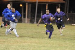 Anthony Clay runs past Coast Guard players as they try to close in to remove the flag during an intramural flag football game here Nov. 3. Regular season play will continue until Jan. 6, followed by the championship playoffs. Clay is a member of the 437th Security Forces Squadron. (U.S. Air Force photo/Staff Sgt. Marie Brown)