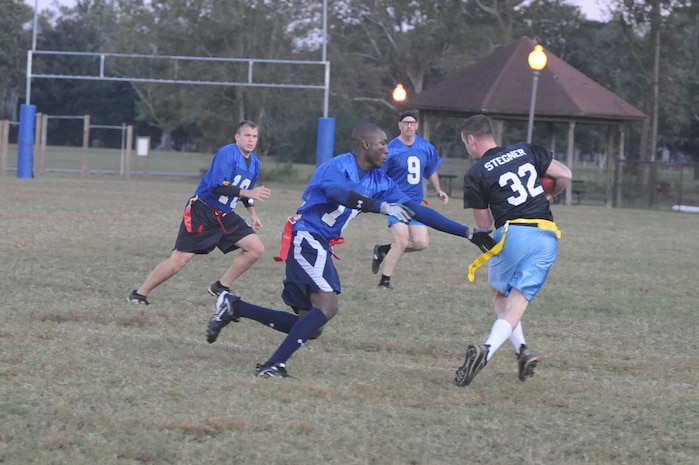 A member of the Coast Guard flag football team reaches to remove the flag from Ross Stegner as he runs the ball on a punt return during an intramural game here Nov. 3. The 437th Security Forces Squadron defeated the Coast Guard 20-6. Cook is a member of the 437 SFS. (U.S. Air Force photo/Staff Sgt. Marie Brown)
